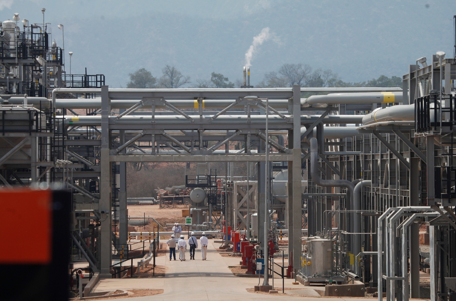 A group walks through an area at the Repsol plant before a ceremony to inaugurate the completion of a new phase at the Margarita-Huacaya gas refinery in the region of Chaco, southeast of Bolivia, Tuesday, Oct. 1, 2013.